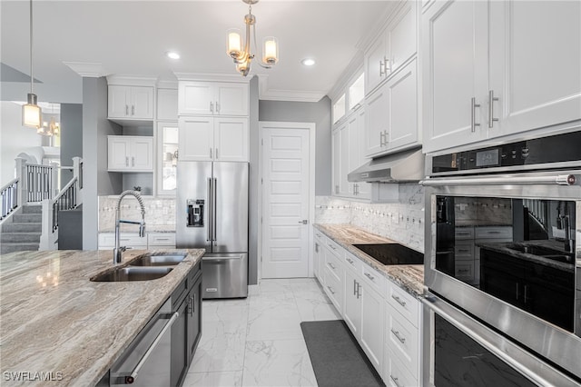 kitchen featuring sink, stainless steel appliances, light stone counters, decorative light fixtures, and white cabinets