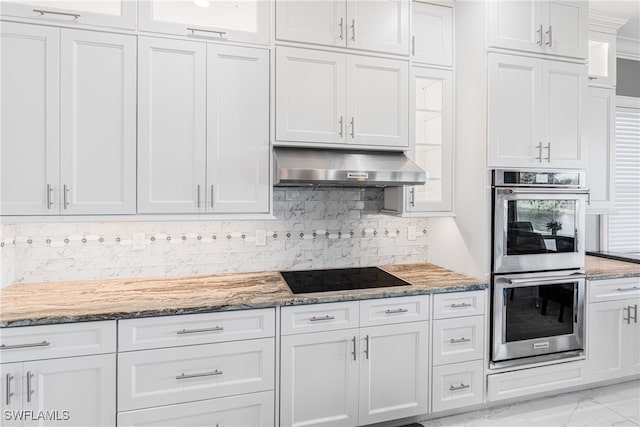 kitchen featuring white cabinets, black electric cooktop, extractor fan, and double oven