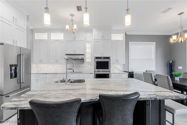 2038 Bahama Ave, Fort Myers, FL 33905 - kitchen with appliances with stainless steel finishes, a chandelier, ornamental molding, tasteful backsplash, and white cabinetry