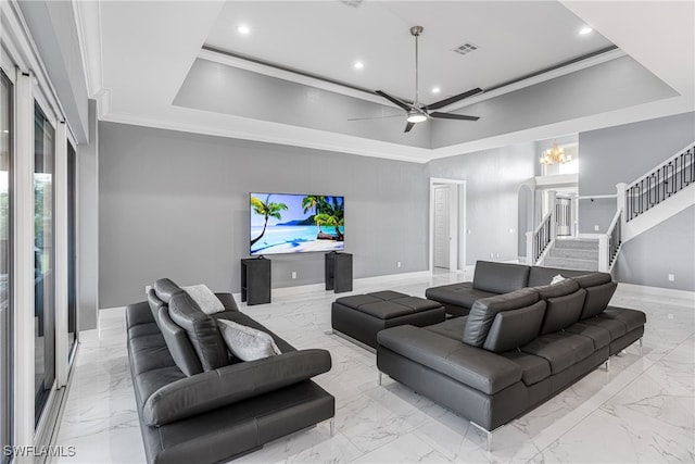 living room with ceiling fan with notable chandelier, a raised ceiling, and crown molding