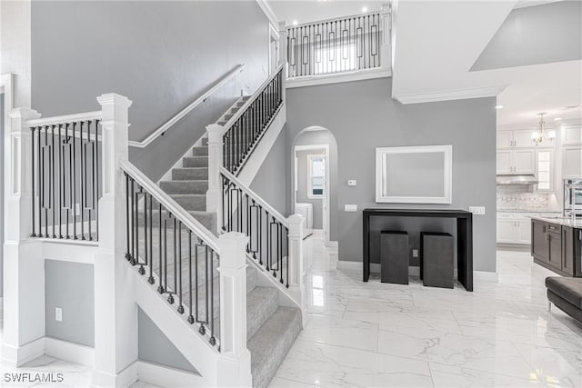 2038 Bahama Ave, Fort Myers, FL 33905 - stairway featuring marble tiled flooring, baseboards, a high ceiling, arched walkways, and healthy amount of natural light