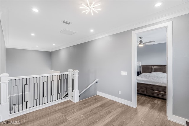 corridor with light hardwood / wood-style floors and ornamental molding