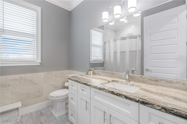 bathroom with walk in shower, vanity, crown molding, tile walls, and toilet