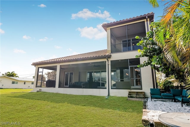 rear view of house featuring a lawn, outdoor lounge area, and a sunroom