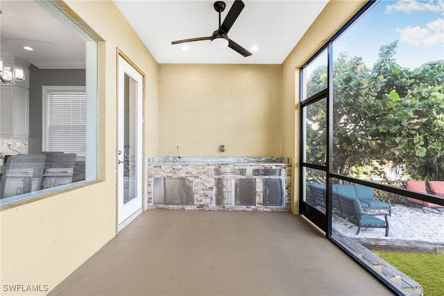 unfurnished sunroom featuring ceiling fan