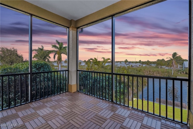 unfurnished sunroom featuring a water view