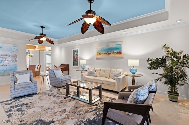 living room featuring ceiling fan with notable chandelier, light tile patterned flooring, crown molding, and a tray ceiling