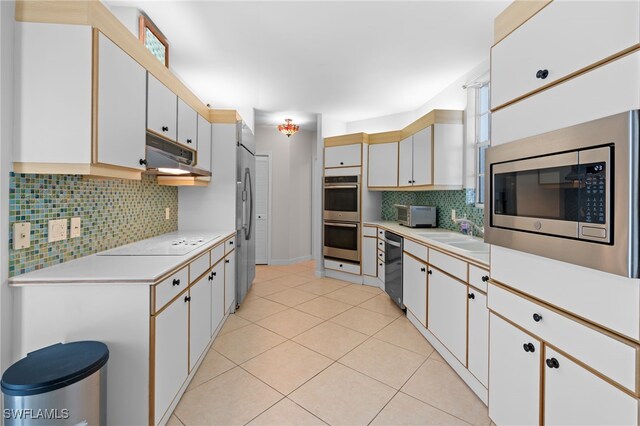 2000 Royal Marco Way Unit 2-407, Marco Island, FL 34145 - kitchen featuring appliances with stainless steel finishes, light countertops, a sink, tasteful backsplash, and under cabinet range hood