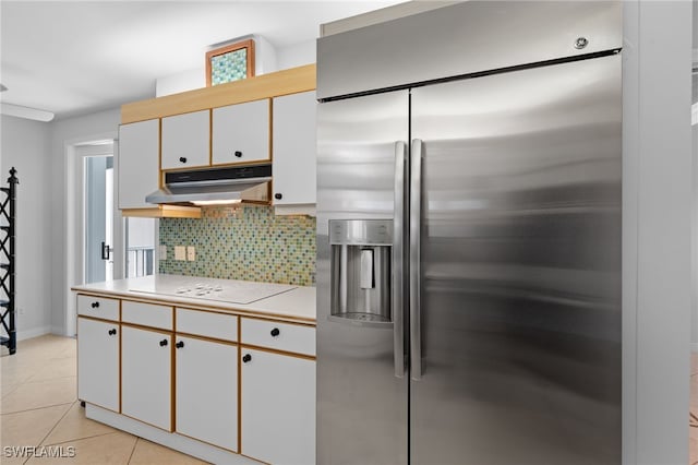 kitchen featuring tasteful backsplash, white electric stovetop, stainless steel fridge with ice dispenser, white cabinetry, and light tile patterned flooring