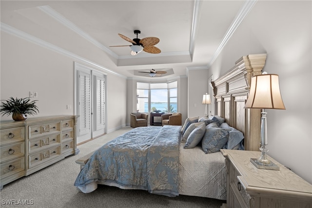 bedroom with ceiling fan, light colored carpet, ornamental molding, and a tray ceiling