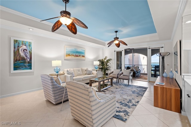 living room featuring a tray ceiling, crown molding, light tile patterned floors, and ceiling fan