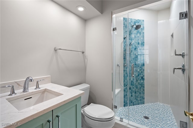 bathroom featuring vanity, an enclosed shower, and toilet