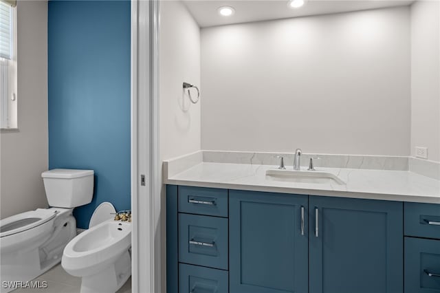 bathroom featuring vanity, tile patterned flooring, a bidet, and toilet