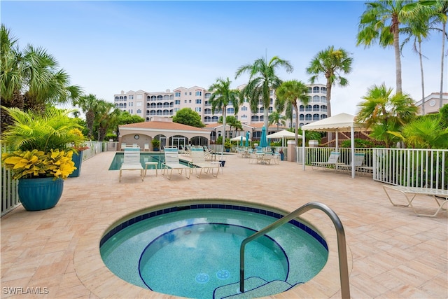 view of swimming pool featuring a patio and a hot tub