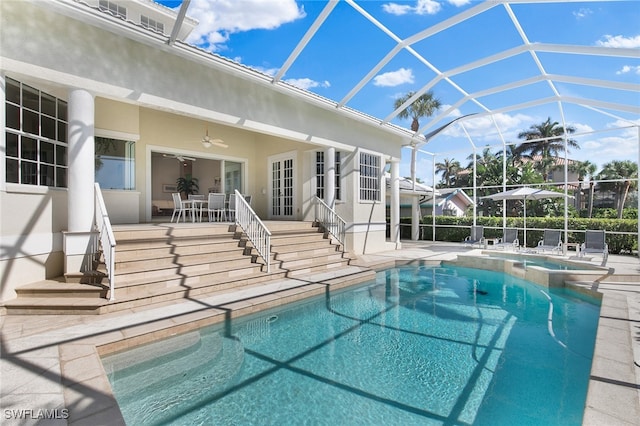 view of swimming pool featuring glass enclosure, ceiling fan, and a patio area