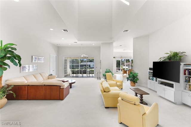 living room with light carpet and a towering ceiling