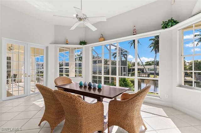 sunroom with ceiling fan, vaulted ceiling, a water view, and french doors