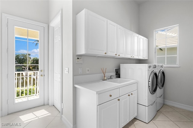 laundry room with washing machine and clothes dryer, sink, light tile patterned flooring, and cabinets