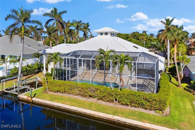 rear view of property featuring a water view and glass enclosure