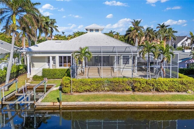 back of house featuring a water view, a patio area, and a lanai