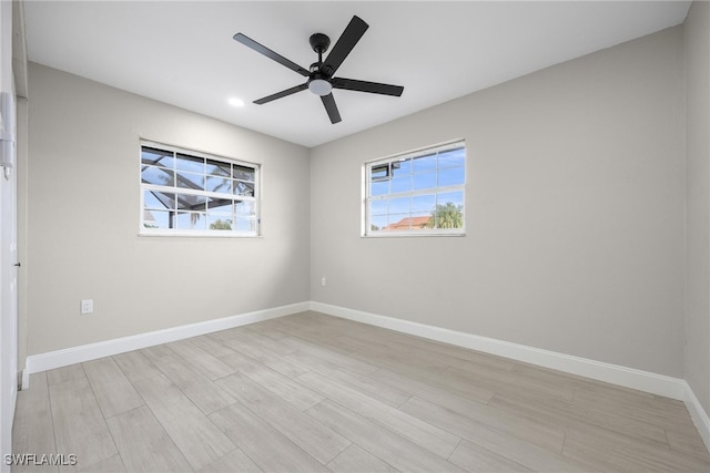 empty room with ceiling fan and light hardwood / wood-style floors