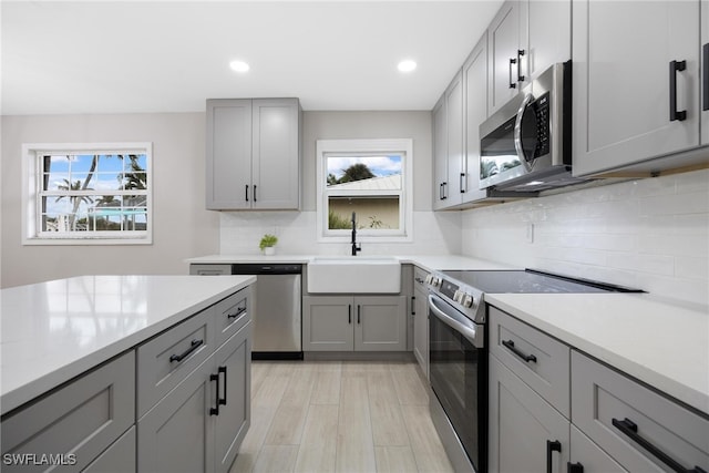 kitchen featuring gray cabinets, light hardwood / wood-style floors, sink, and appliances with stainless steel finishes