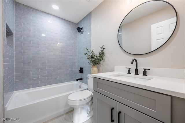 full bathroom featuring toilet, vanity, and tiled shower / bath