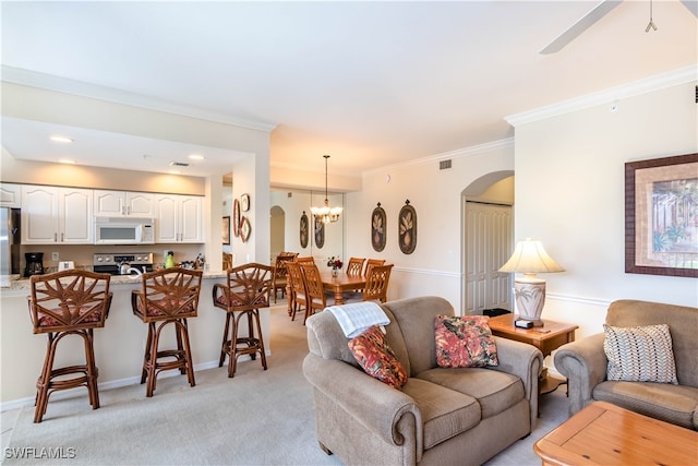 carpeted living room featuring ceiling fan with notable chandelier and crown molding