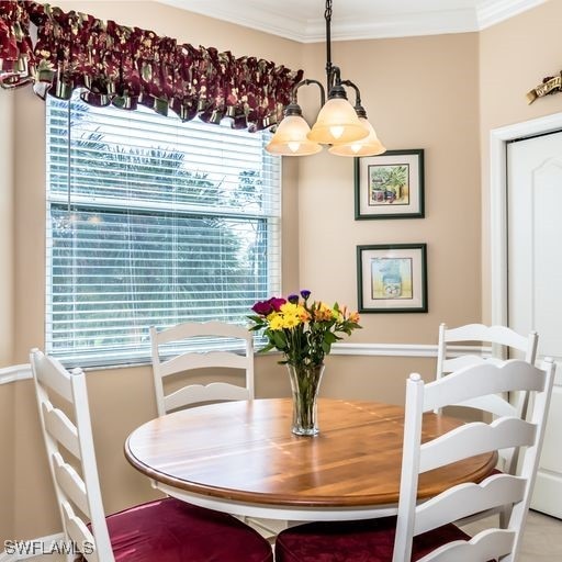 dining area with crown molding and a notable chandelier