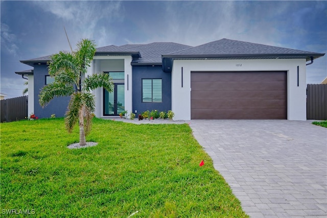 view of front of home featuring a front yard and a garage