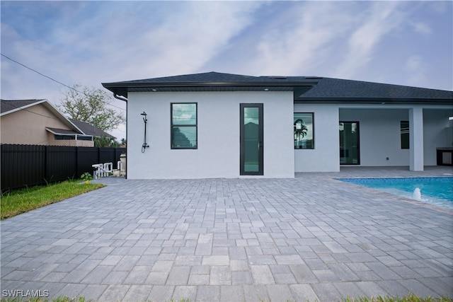 back of house with a fenced in pool, a patio area, and pool water feature