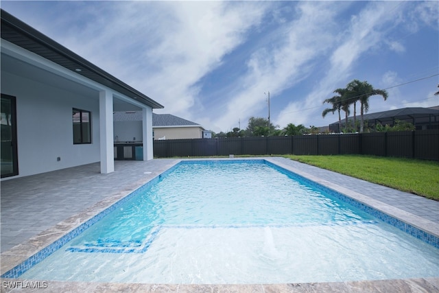 view of pool featuring a patio area and a yard