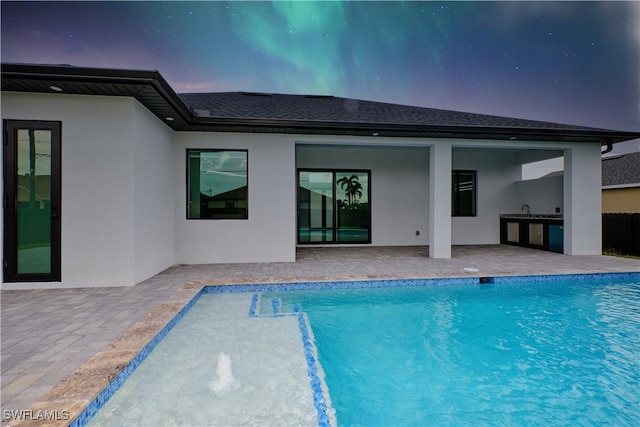 view of pool featuring sink, a patio, and an outdoor kitchen