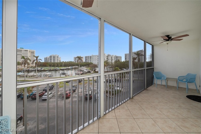 balcony featuring ceiling fan and a water view