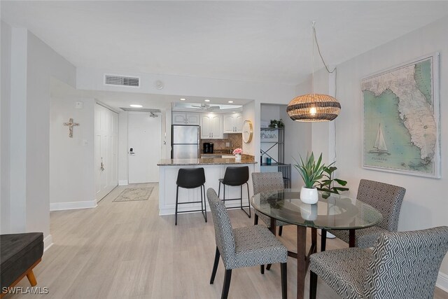 1 Bluebill Ave Unit 401, Naples, FL 34108 - dining area with baseboards, light wood finished floors, and visible vents