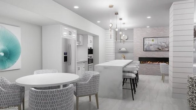 dining room with a stone fireplace and decorative columns