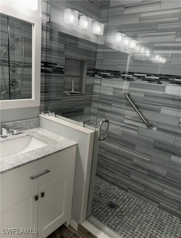 bathroom with vanity and a shower with shower door