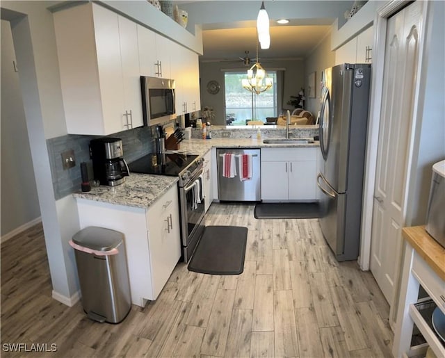 kitchen with sink, stainless steel appliances, light hardwood / wood-style floors, pendant lighting, and white cabinets