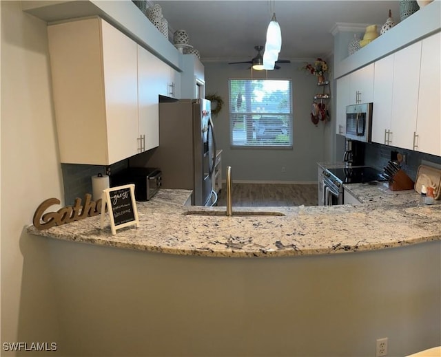 kitchen featuring white cabinetry, stainless steel appliances, crown molding, hardwood / wood-style floors, and pendant lighting