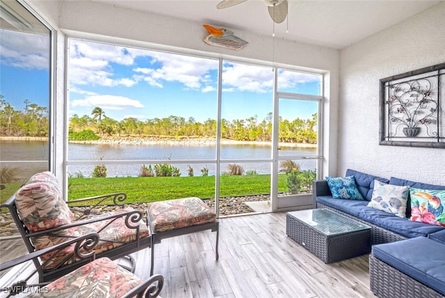 unfurnished sunroom with ceiling fan and a water view