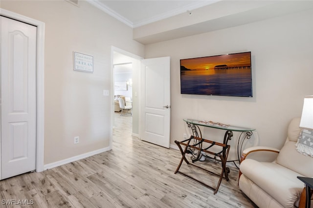 sitting room with crown molding and light hardwood / wood-style floors