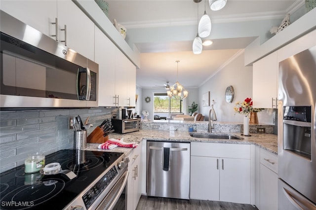 kitchen featuring white cabinets, crown molding, sink, hanging light fixtures, and stainless steel appliances