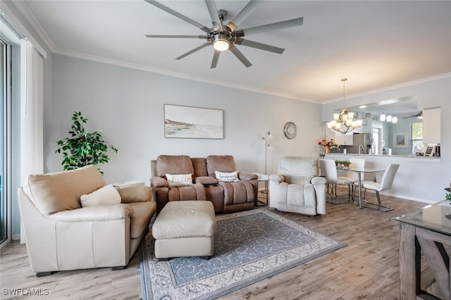 living room featuring ceiling fan with notable chandelier, light hardwood / wood-style flooring, and crown molding