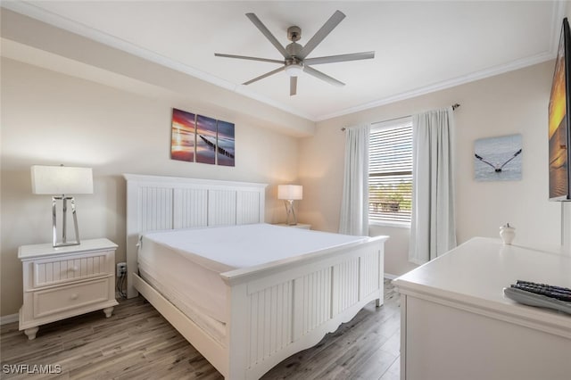 bedroom with ceiling fan, ornamental molding, and hardwood / wood-style flooring