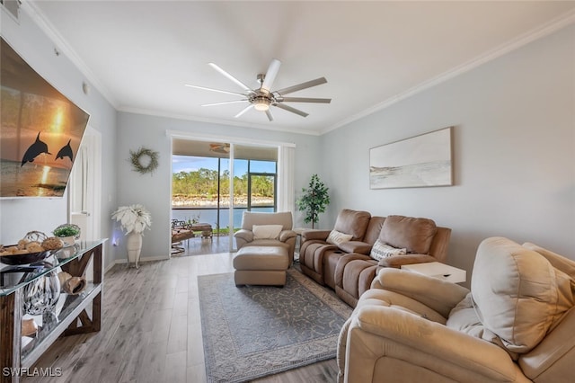 living room featuring ornamental molding, a water view, ceiling fan, and light hardwood / wood-style floors