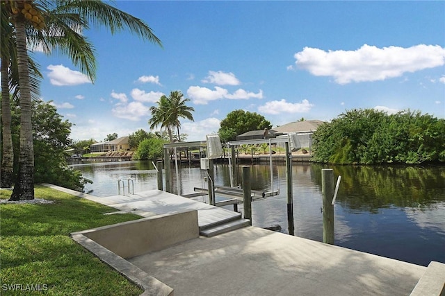 dock area with a lawn and a water view