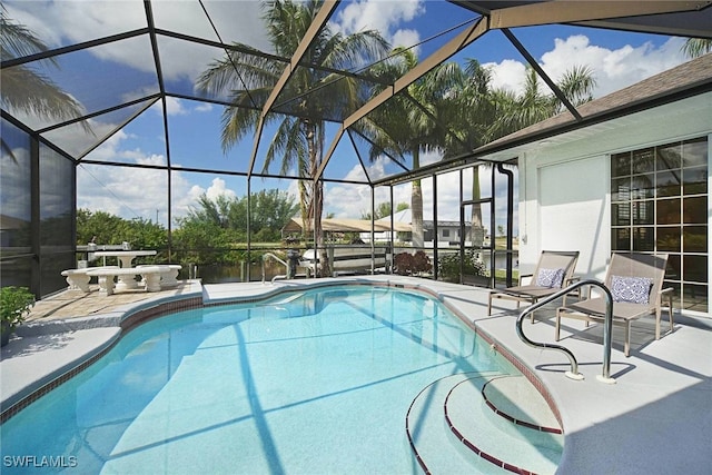 view of swimming pool featuring a lanai and a patio area