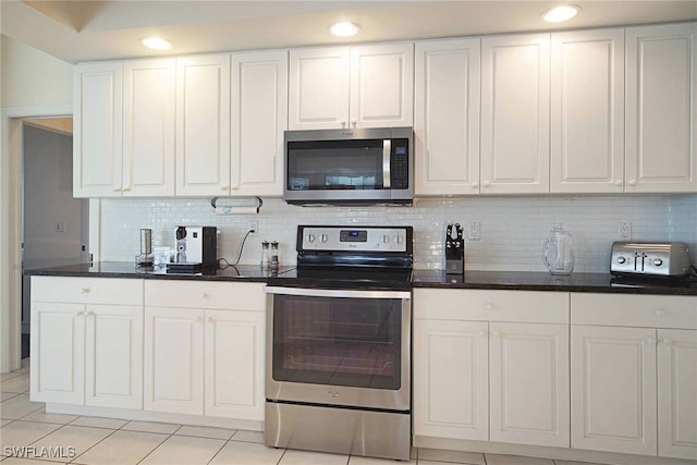 kitchen with tasteful backsplash, white cabinetry, light tile patterned floors, and stainless steel appliances