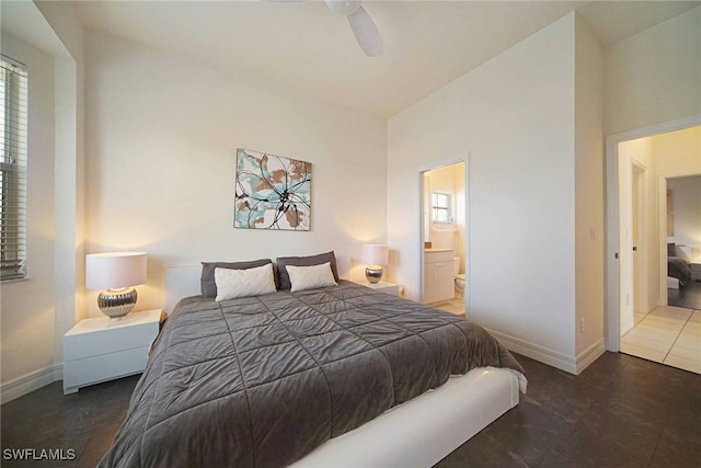 bedroom with connected bathroom, dark tile patterned floors, ceiling fan, and lofted ceiling