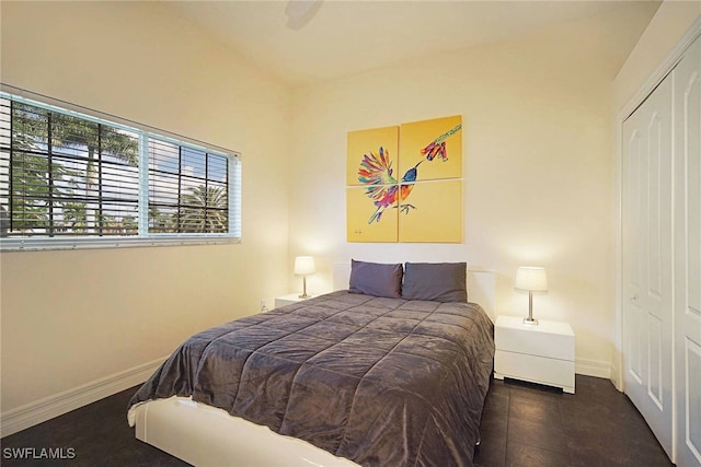 bedroom with dark tile patterned floors and a closet